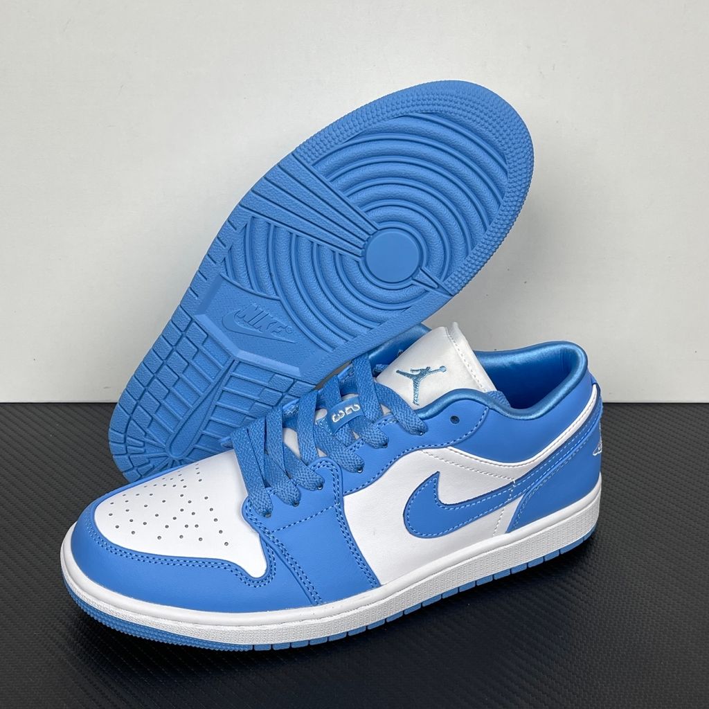Side profile of the Air Jordan 1 Low sneaker in a classic 'UNC' colorway, featuring a crisp white leather base with vibrant University Blue overlays, a matching Swoosh, and a white midsole resting on a blue rubber outsole.