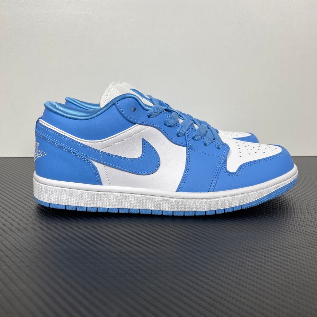 Side profile of the Air Jordan 1 Low sneaker in a classic 'UNC' colorway, featuring a crisp white leather base with vibrant University Blue overlays, a matching Swoosh, and a white midsole resting on a blue rubber outsole.