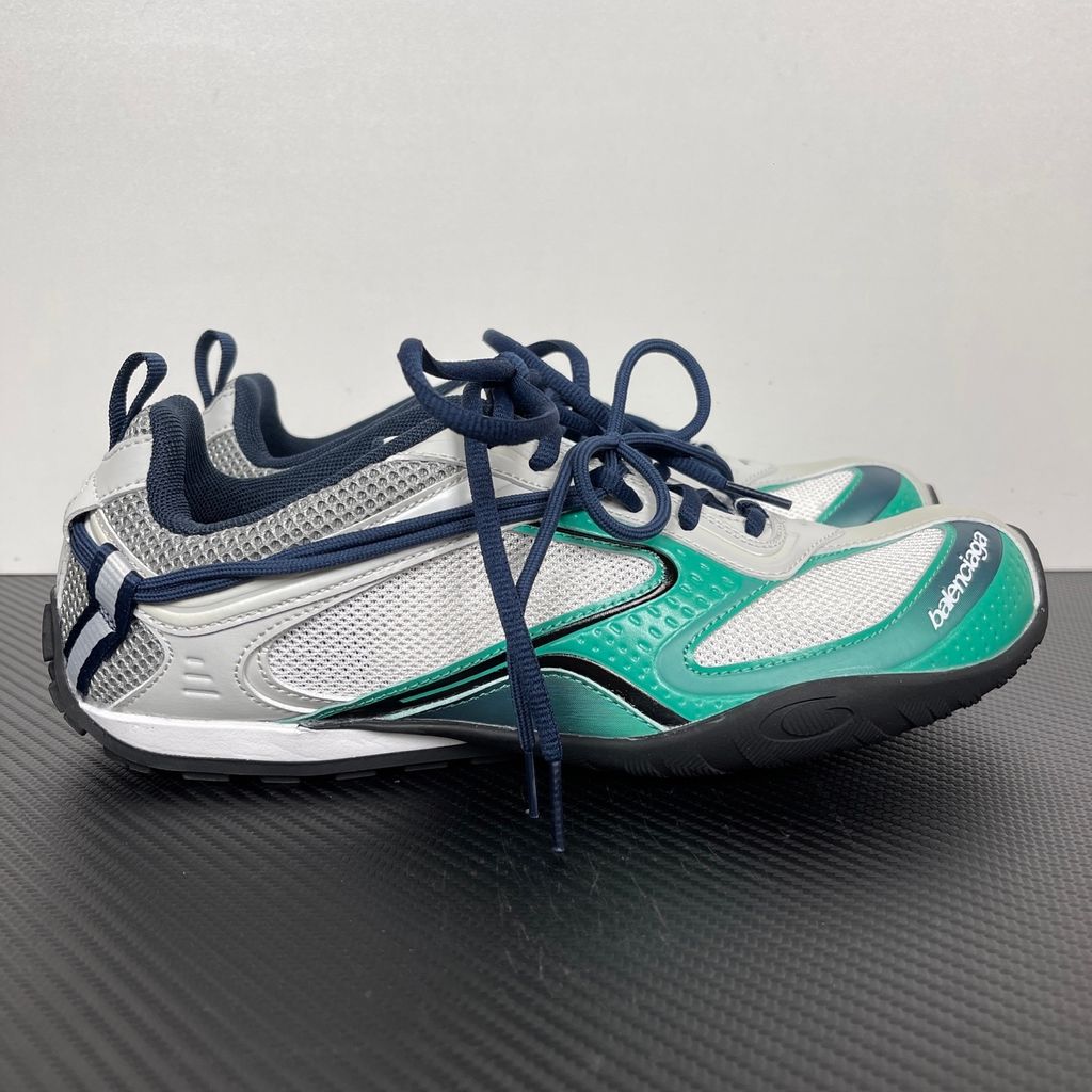Side profile of the Balenciaga Radar sneaker in a light grey, neon green, and black colorway, featuring dynamic gradient lines across a layered mesh and synthetic upper, resting on an aggressive, chunky sculpted sole.