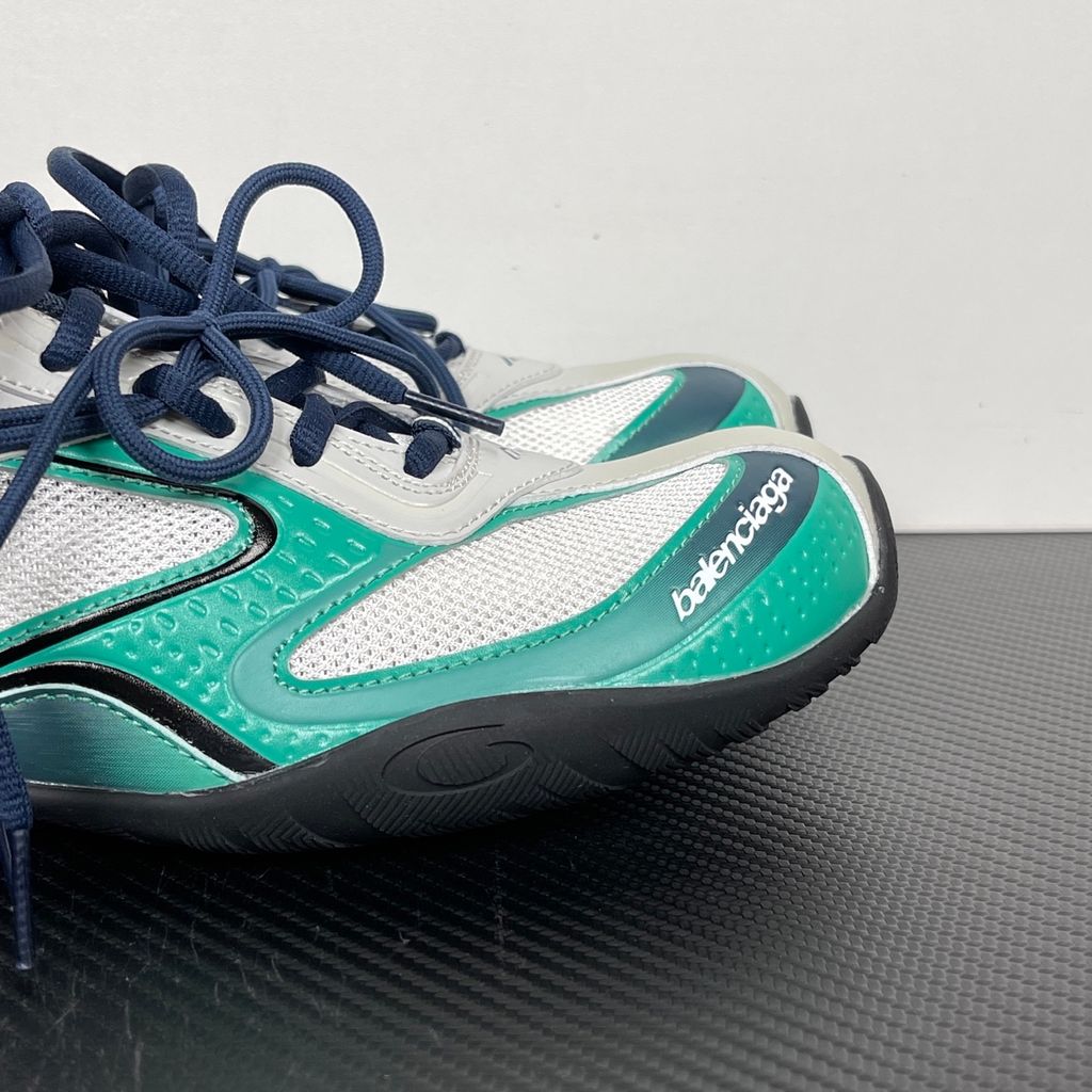 Side profile of the Balenciaga Radar sneaker in a light grey, neon green, and black colorway, featuring dynamic gradient lines across a layered mesh and synthetic upper, resting on an aggressive, chunky sculpted sole.