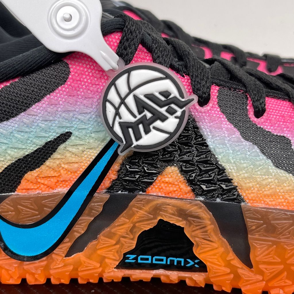 Side profile of the Nike Ja 3 'At Dawn' basketball sneaker, featuring a sleek, lightweight dark mesh upper contrasted by vibrant sunrise-inspired gradient accents, resting on a supportive midsole equipped with Zoom Air cushioning.