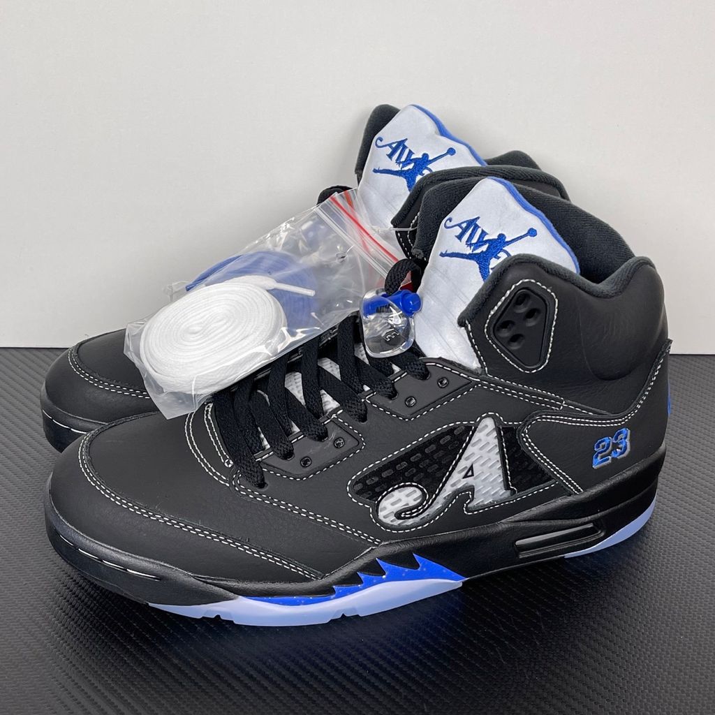 Side profile of the Jordan 5 Retro x Awake NY sneaker in a stealthy black colorway, featuring a premium textured upper, classic translucent midfoot netting, reflective tongue detailing, and signature co-branding on the heel.