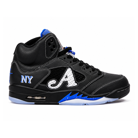 Side profile of the Jordan 5 Retro x Awake NY sneaker in a stealthy black colorway, featuring a premium textured upper, classic translucent midfoot netting, reflective tongue detailing, and signature co-branding on the heel.