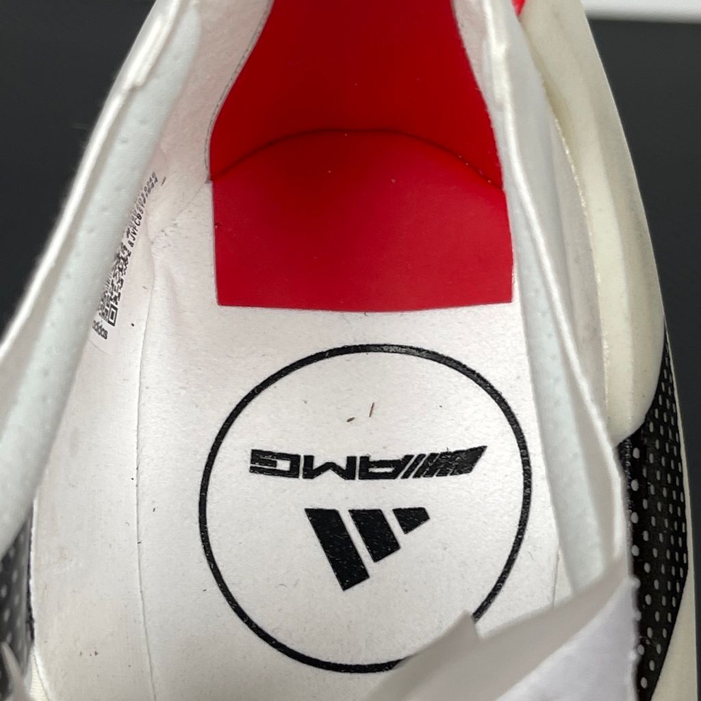 Side profile of the adidas Adizero Prime X EVO running shoe featuring a breathable Cloud White upper, striking Core Black Three Stripes branding, vibrant Lucid Red accents, and a massive, hyper-stacked Lightstrike Pro foam midsole.