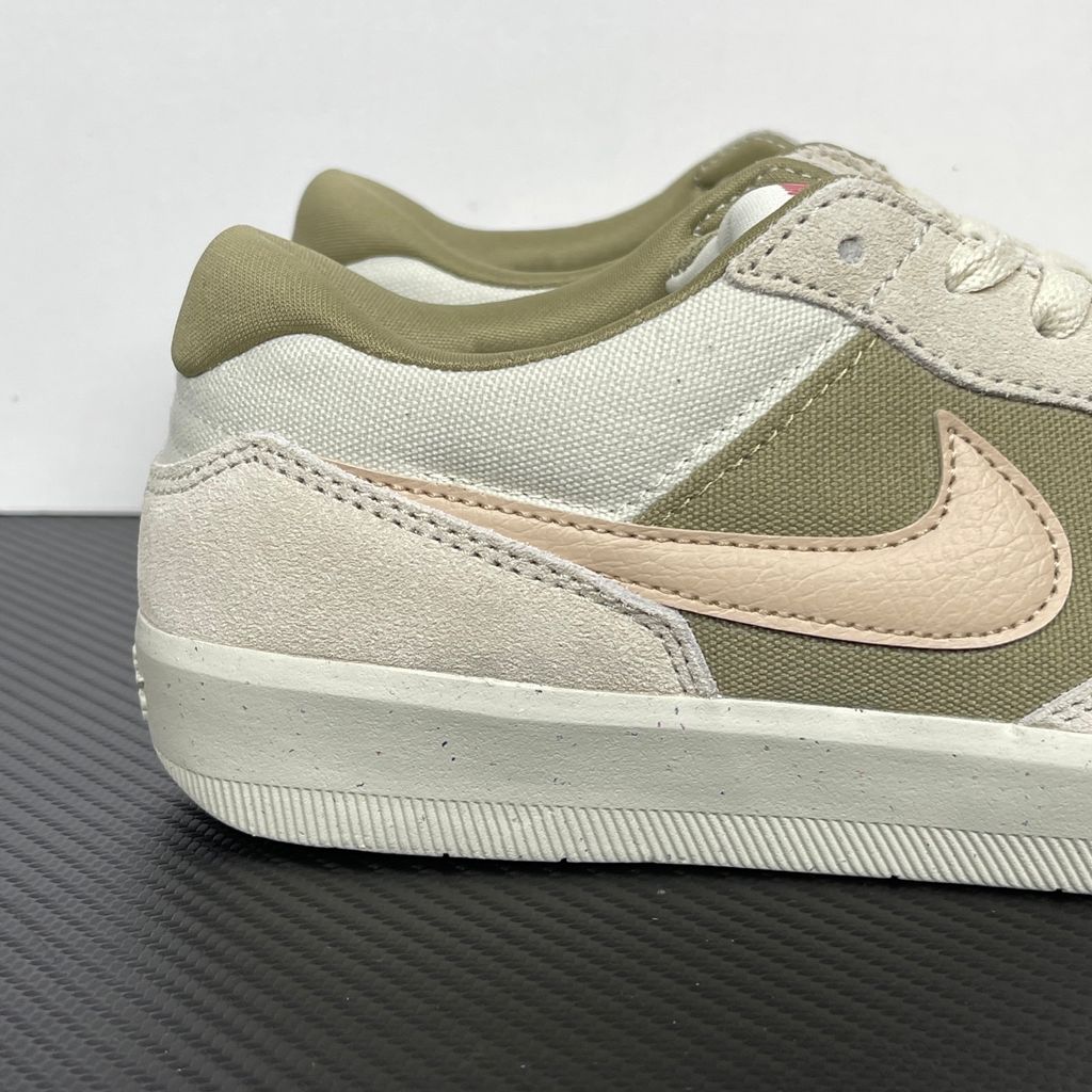 Side profile of the Nike SB Force 58 skate shoe featuring a creamy Coconut Milk canvas and suede upper, accented by a Neutral Olive green Swoosh and detailing, resting on a crisp white sole with a flexible tri-star tread.