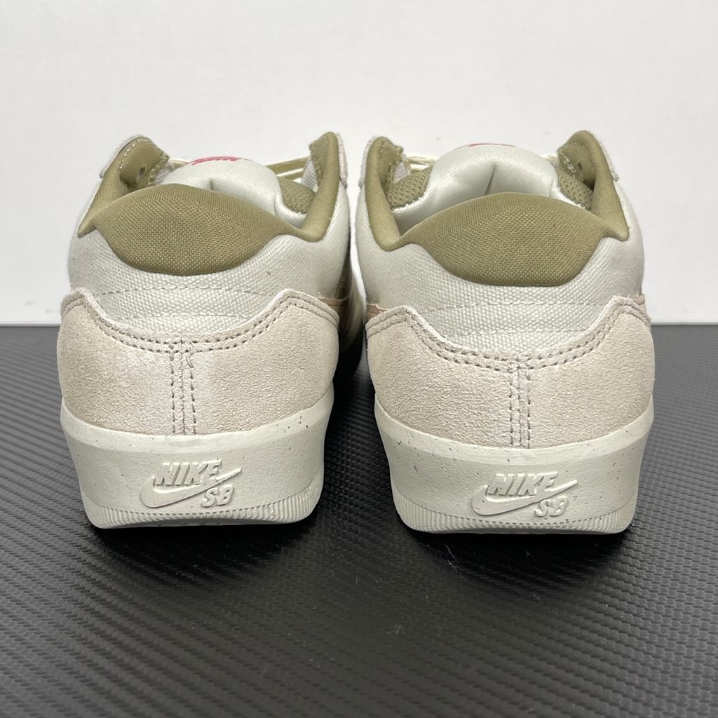 Side profile of the Nike SB Force 58 skate shoe featuring a creamy Coconut Milk canvas and suede upper, accented by a Neutral Olive green Swoosh and detailing, resting on a crisp white sole with a flexible tri-star tread.