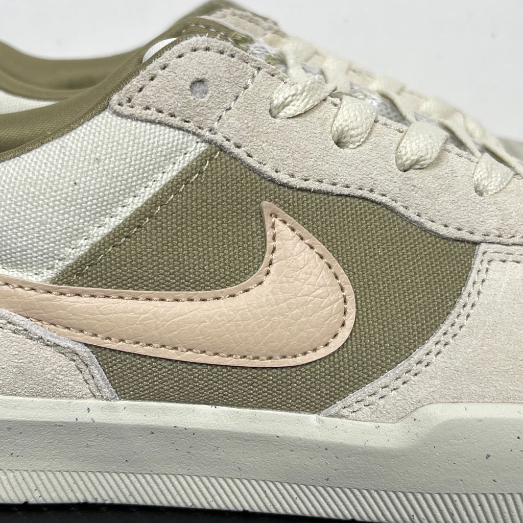 Side profile of the Nike SB Force 58 skate shoe featuring a creamy Coconut Milk canvas and suede upper, accented by a Neutral Olive green Swoosh and detailing, resting on a crisp white sole with a flexible tri-star tread.