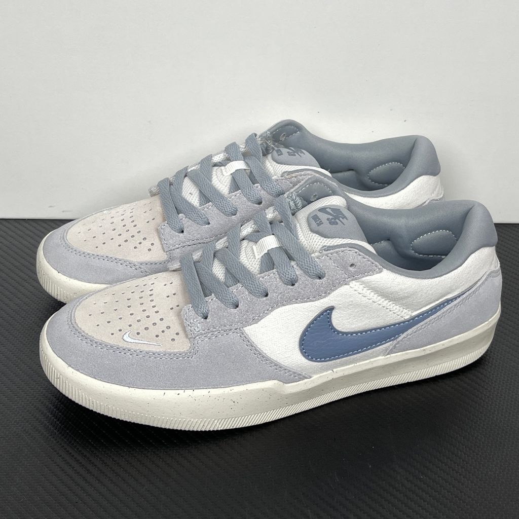 Side profile of the Nike SB Force 58 skate shoe featuring a creamy Coconut Milk canvas and suede upper, accented by a Neutral Olive green Swoosh and detailing, resting on a crisp white sole with a flexible tri-star tread.