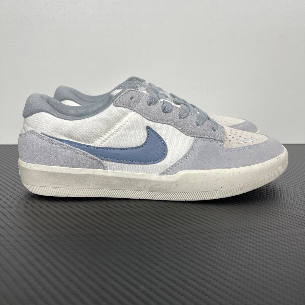 Side profile of the Nike SB Force 58 skate shoe featuring a creamy Coconut Milk canvas and suede upper, accented by a Neutral Olive green Swoosh and detailing, resting on a crisp white sole with a flexible tri-star tread.