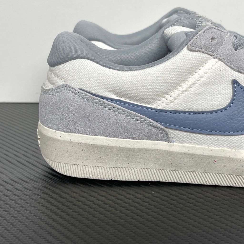 Side profile of the Nike SB Force 58 skate shoe featuring a creamy Coconut Milk canvas and suede upper, accented by a Neutral Olive green Swoosh and detailing, resting on a crisp white sole with a flexible tri-star tread.