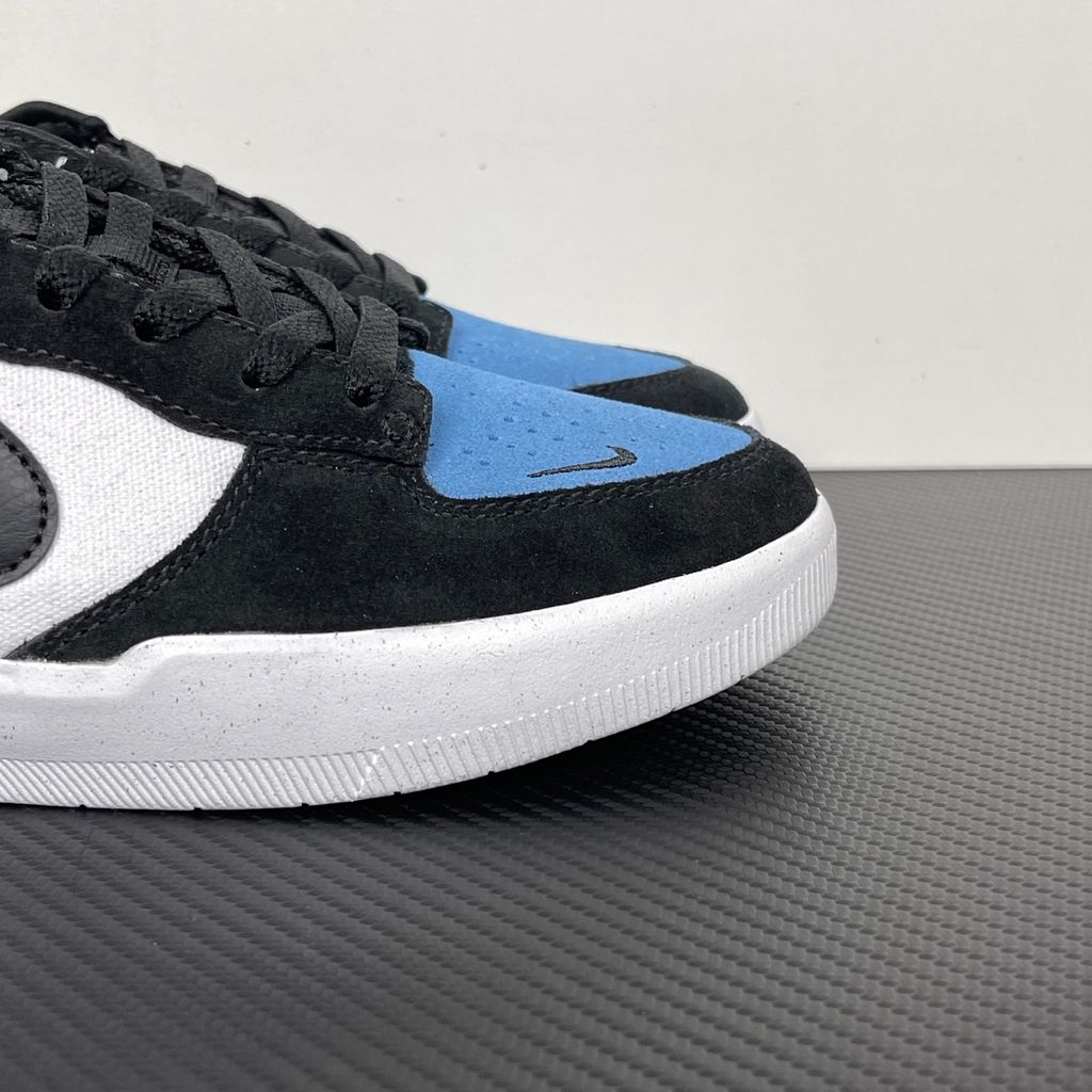 Side profile of the Nike SB Force 58 skate shoe featuring a vibrant Dutch Blue canvas and suede upper, accented by a crisp white Swoosh and detailing, resting on a white sole with a flexible tri-star tread.