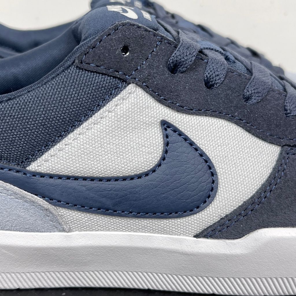 Side profile of the Nike SB Force 58 skate shoe featuring a soft Light Armory Blue canvas and suede upper, accented by a deep Thunder Blue Swoosh and detailing, resting on a crisp white sole with a flexible tri-star tread.