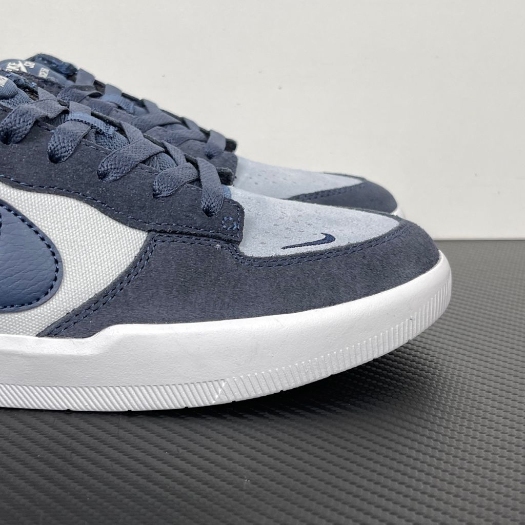 Side profile of the Nike SB Force 58 skate shoe featuring a soft Light Armory Blue canvas and suede upper, accented by a deep Thunder Blue Swoosh and detailing, resting on a crisp white sole with a flexible tri-star tread.