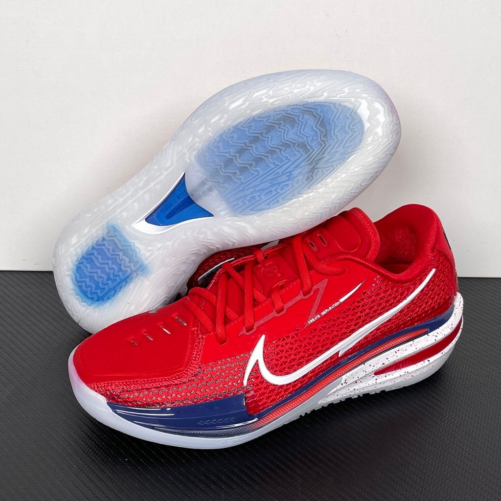 Side profile of the Nike Air Zoom G.T. Cut basketball shoe in the Team USA colorway, featuring a vibrant Sport Red engineered mesh upper, contrasted by navy blue detailing, a crisp white Swoosh, and a highly sculpted responsive sole unit.