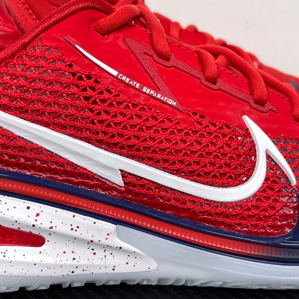 Side profile of the Nike Air Zoom G.T. Cut basketball shoe in the Team USA colorway, featuring a vibrant Sport Red engineered mesh upper, contrasted by navy blue detailing, a crisp white Swoosh, and a highly sculpted responsive sole unit.