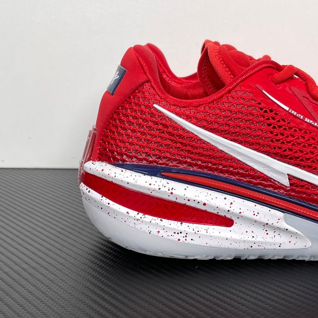 Side profile of the Nike Air Zoom G.T. Cut basketball shoe in the Team USA colorway, featuring a vibrant Sport Red engineered mesh upper, contrasted by navy blue detailing, a crisp white Swoosh, and a highly sculpted responsive sole unit.