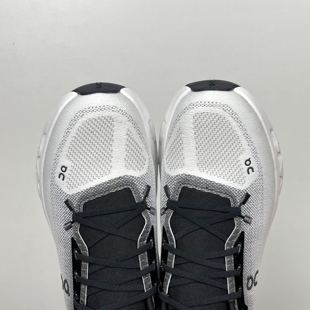 Side profile of the On Running Cloudtilt sneaker featuring a sleek, lightweight black knit upper with a sock-like collar, integrated speed lacing, and a contrasting ivory midsole showcasing the collapsing CloudTec Phase® pods.