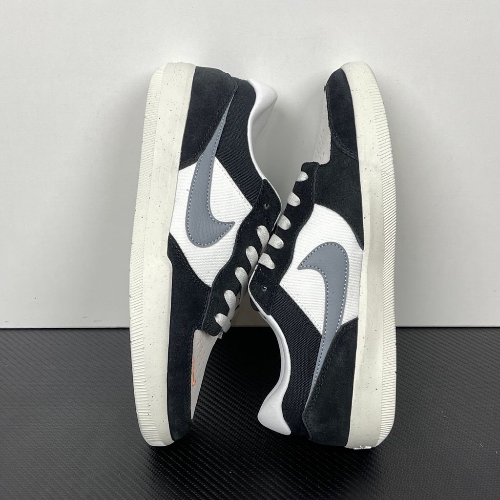 Side profile of the Nike SB Force 58 skate shoe featuring a sleek Black suede and Cool Gray canvas upper, accented by a crisp Mountain Peak White Swoosh and detailing, resting on a white sole with a flexible tri-star tread.