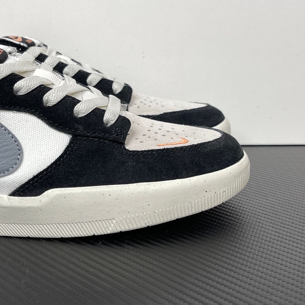 Side profile of the Nike SB Force 58 skate shoe featuring a sleek Black suede and Cool Gray canvas upper, accented by a crisp Mountain Peak White Swoosh and detailing, resting on a white sole with a flexible tri-star tread.