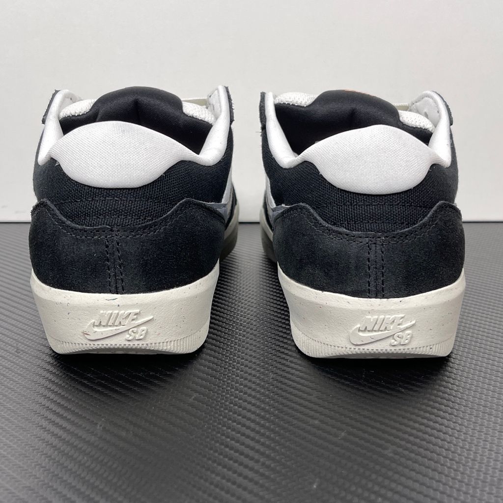 Side profile of the Nike SB Force 58 skate shoe featuring a sleek Black suede and Cool Gray canvas upper, accented by a crisp Mountain Peak White Swoosh and detailing, resting on a white sole with a flexible tri-star tread.