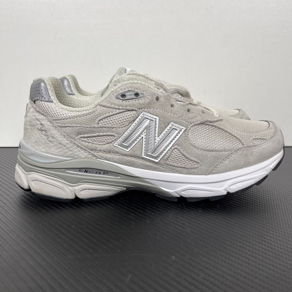 Side profile of the collaborative New Balance 990v3 MiUSA sneaker in the exclusive Kith Hallow colorway, featuring a premium tonal pigskin suede and mesh upper, a silver reflective 'N' logo, and a split ENCAP midsole.