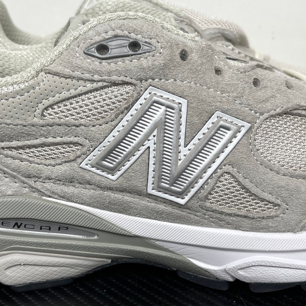 Side profile of the collaborative New Balance 990v3 MiUSA sneaker in the exclusive Kith Hallow colorway, featuring a premium tonal pigskin suede and mesh upper, a silver reflective 'N' logo, and a split ENCAP midsole.