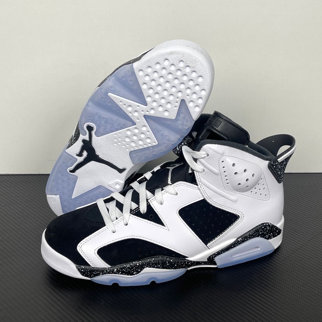 Side profile of the Air Jordan 6 Retro 'Oreo' (2026) sneaker featuring a crisp white leather upper, contrasting black nubuck underlays, signature speckled midsole detailing, an iconic lace toggle, and an icy translucent rubber outsole.