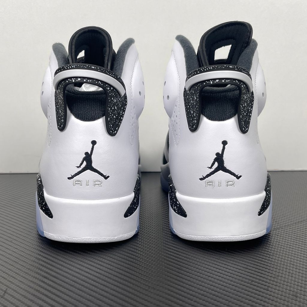 Side profile of the Air Jordan 6 Retro 'Oreo' (2026) sneaker featuring a crisp white leather upper, contrasting black nubuck underlays, signature speckled midsole detailing, an iconic lace toggle, and an icy translucent rubber outsole.