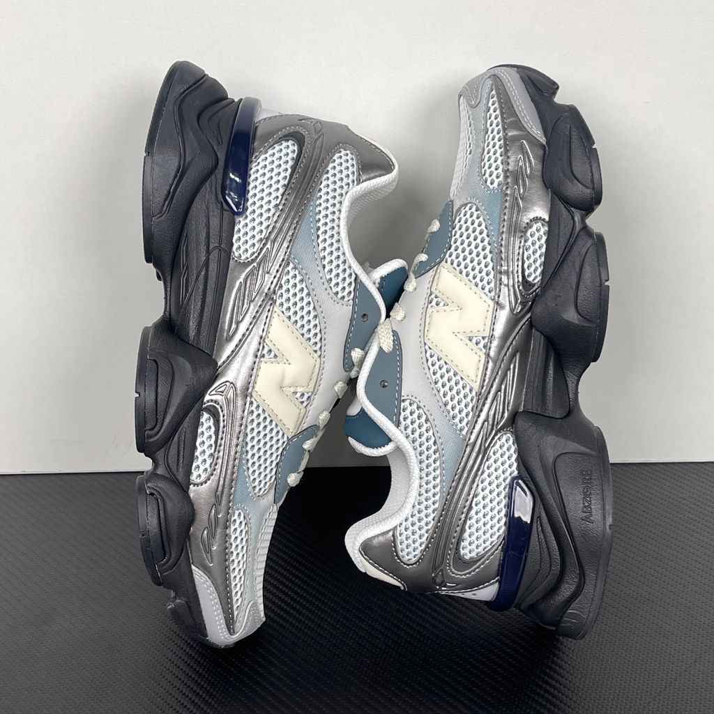 Side profile of the New Balance 9060 sneaker featuring a white open-mesh upper, striking metallic silver overlays, a cream 'N' logo, and a dramatic, chunky black wavy midsole with ABZORB cushioning.