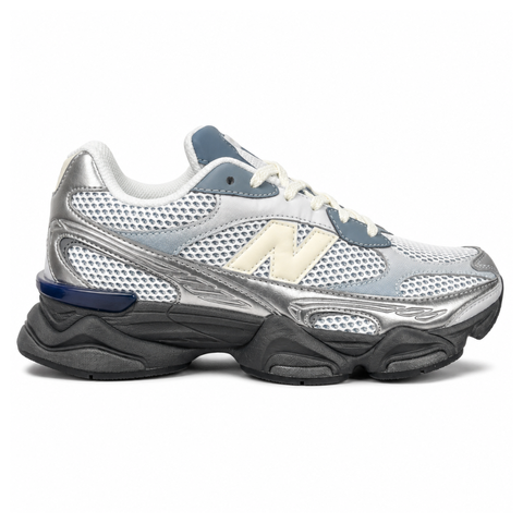 Side profile of the New Balance 9060 sneaker featuring a white open-mesh upper, striking metallic silver overlays, a cream 'N' logo, and a dramatic, chunky black wavy midsole with ABZORB cushioning.