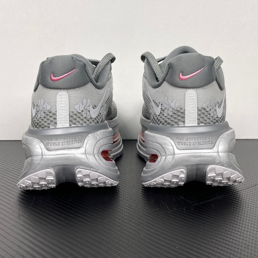 Side profile of the Nike Vomero Premium QS sneaker in a refined Fleur De-Lis and Geyser Grey colorway, featuring a layered mesh and premium synthetic upper, signature plastic side cage, and a responsive Zoom Air midsole.