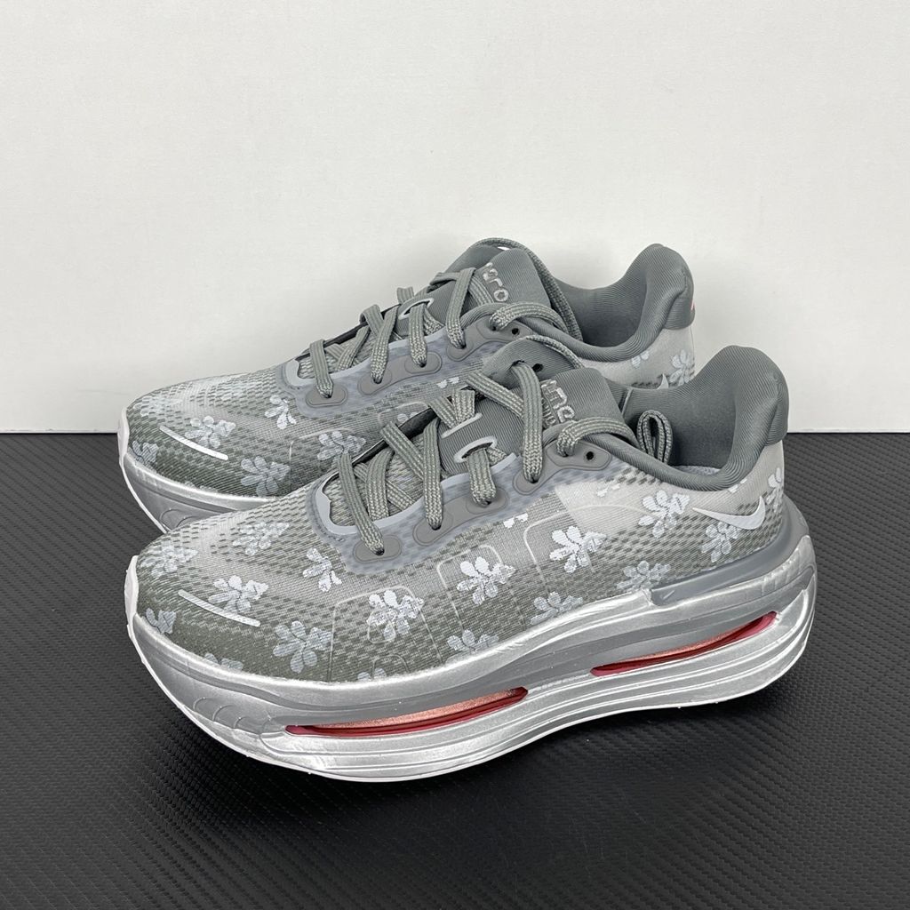 Side profile of the Nike Vomero Premium QS sneaker in a refined Fleur De-Lis and Geyser Grey colorway, featuring a layered mesh and premium synthetic upper, signature plastic side cage, and a responsive Zoom Air midsole.