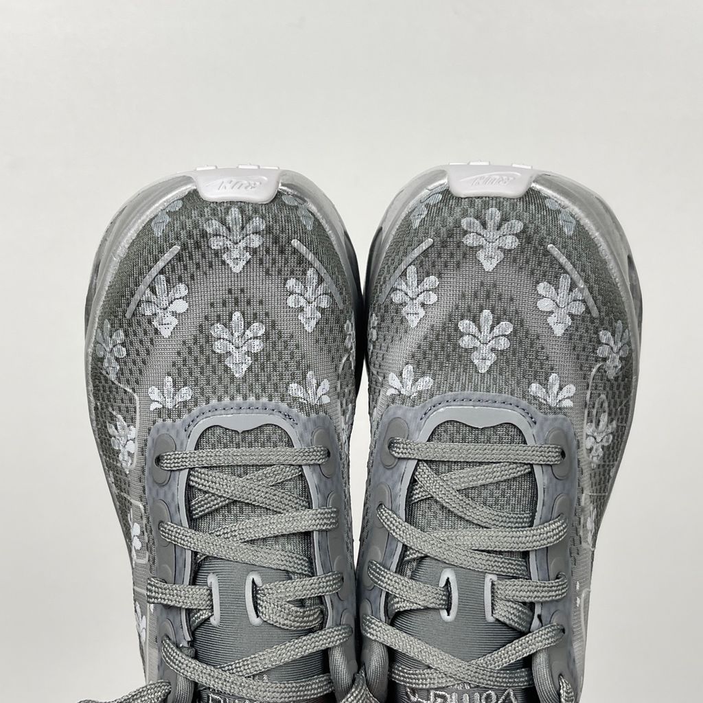Side profile of the Nike Vomero Premium QS sneaker in a refined Fleur De-Lis and Geyser Grey colorway, featuring a layered mesh and premium synthetic upper, signature plastic side cage, and a responsive Zoom Air midsole.