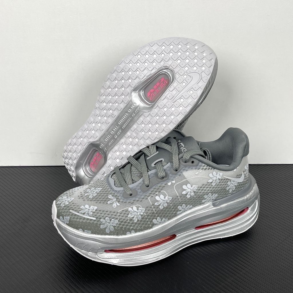 Side profile of the Nike Vomero Premium QS sneaker in a refined Fleur De-Lis and Geyser Grey colorway, featuring a layered mesh and premium synthetic upper, signature plastic side cage, and a responsive Zoom Air midsole.