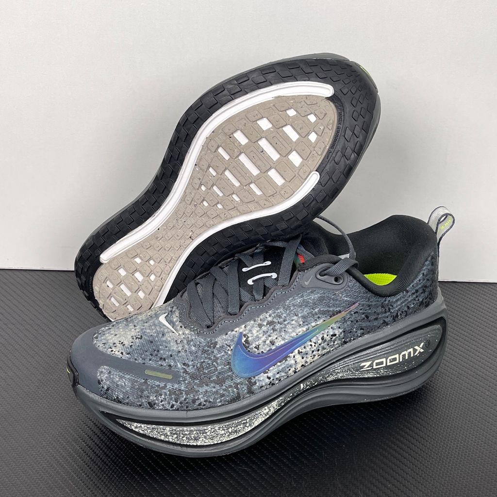 Side profile of the Nike Vomero Plus sneaker in a dark Anthracite and Black colorway with subtle Oatmeal accents, featuring a layered mesh and synthetic upper, a structured midfoot cage, and a responsive Zoom Air midsole.