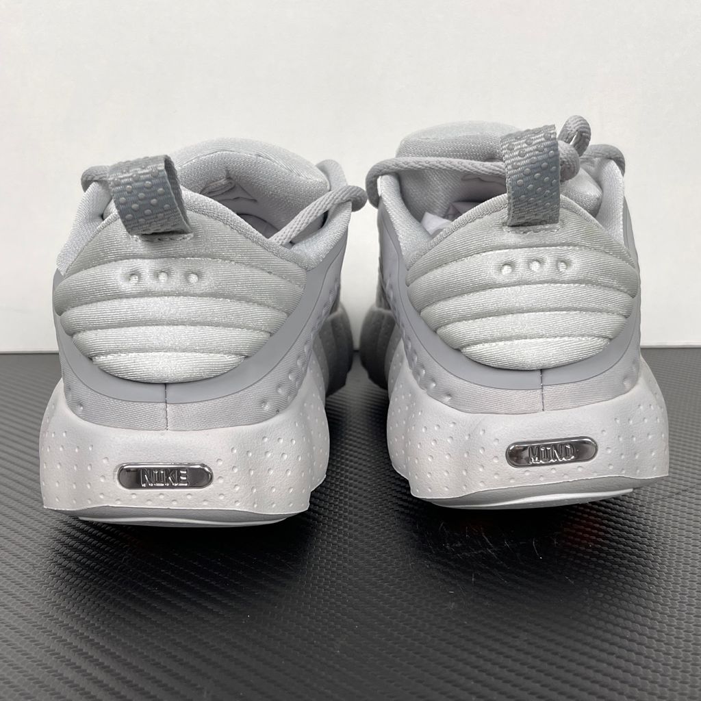 Side profile of the Nike Vomero Plus sneaker in a dark Anthracite and Black colorway with subtle Oatmeal accents, featuring a layered mesh and synthetic upper, a structured midfoot cage, and a responsive Zoom Air midsole.