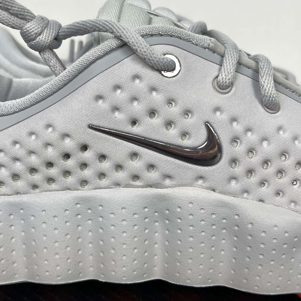 Side profile of the Nike Vomero Plus sneaker in a dark Anthracite and Black colorway with subtle Oatmeal accents, featuring a layered mesh and synthetic upper, a structured midfoot cage, and a responsive Zoom Air midsole.
