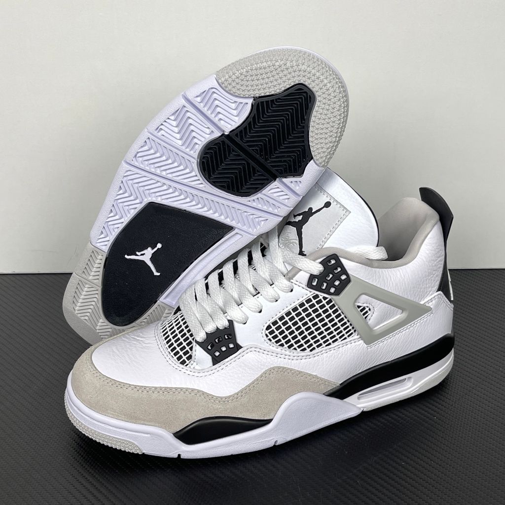 Side profile of the Air Jordan 4 Retro 'Military Black' sneaker featuring a crisp white tumbled leather upper, a light grey suede toe wrap, contrasting black TPU support wings and heel tab, and a white midsole with a visible Air unit.