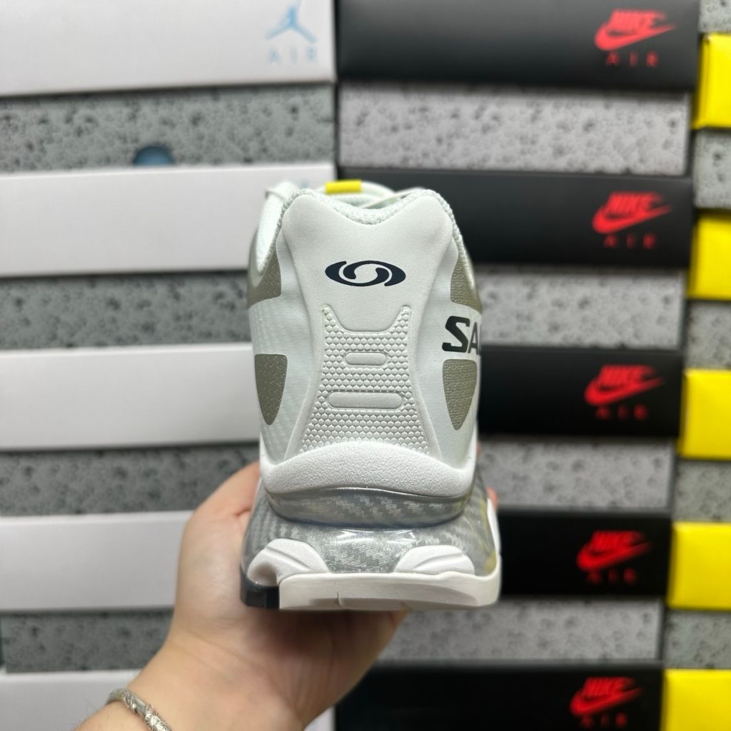 Side profile of the Salomon XT-4 OG trail running sneaker in a clean White and Lunar Rock colorway, featuring a durable TPU film mesh upper, a Quicklace system, and an aggressive Contagrip rubber outsole.