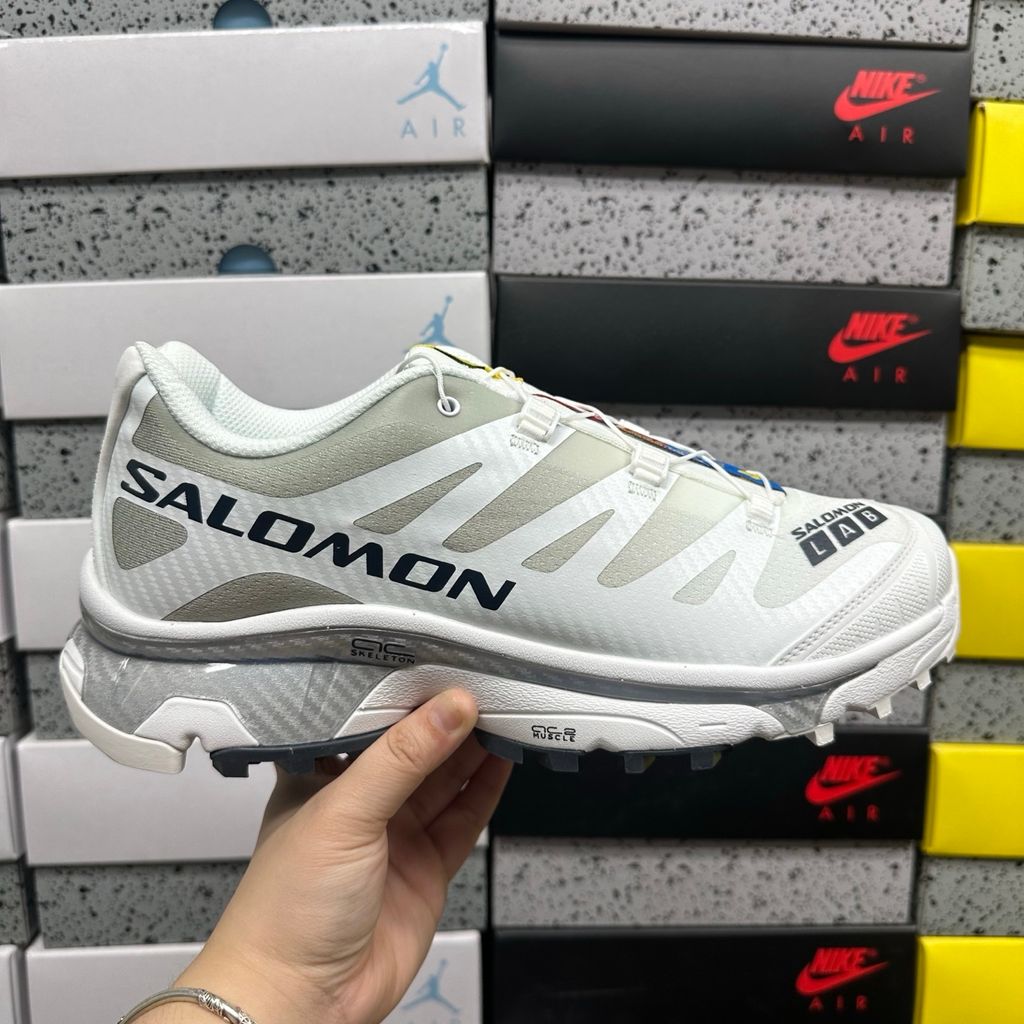 Side profile of the Salomon XT-4 OG trail running sneaker in a clean White and Lunar Rock colorway, featuring a durable TPU film mesh upper, a Quicklace system, and an aggressive Contagrip rubber outsole.