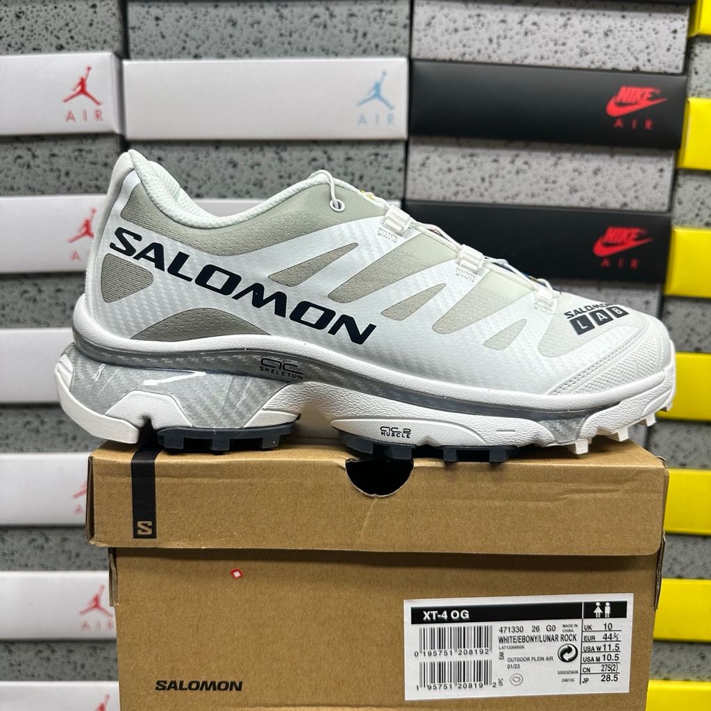 Side profile of the Salomon XT-4 OG trail running sneaker in a clean White and Lunar Rock colorway, featuring a durable TPU film mesh upper, a Quicklace system, and an aggressive Contagrip rubber outsole.
