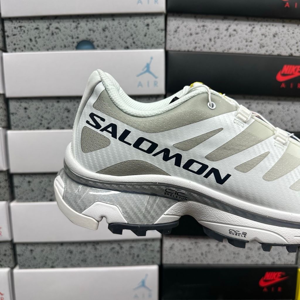 Side profile of the Salomon XT-4 OG trail running sneaker in a clean White and Lunar Rock colorway, featuring a durable TPU film mesh upper, a Quicklace system, and an aggressive Contagrip rubber outsole.