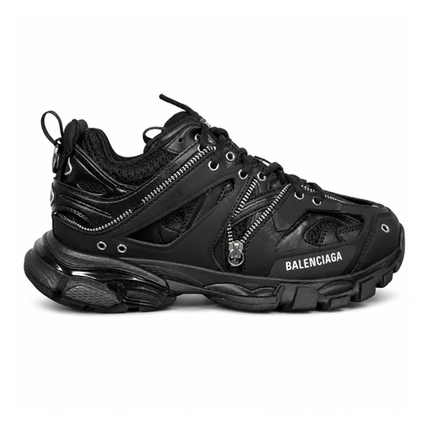 Side profile of the Balenciaga Track LED sneaker in an all-black colorway, featuring a complex layered mesh and synthetic upper, metallic zipper embellishments across the side panels, a chunky augmented sole, and a built-in LED heel display.