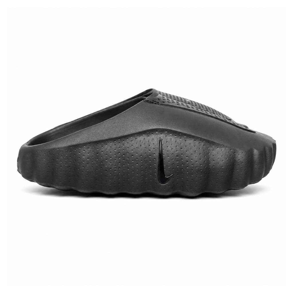 Side profile of the Nike Mind 001 Slide in a sleek Triple Black colorway, featuring a seamless, minimalist foam construction, a contoured footbed, and a durable traction outsole.