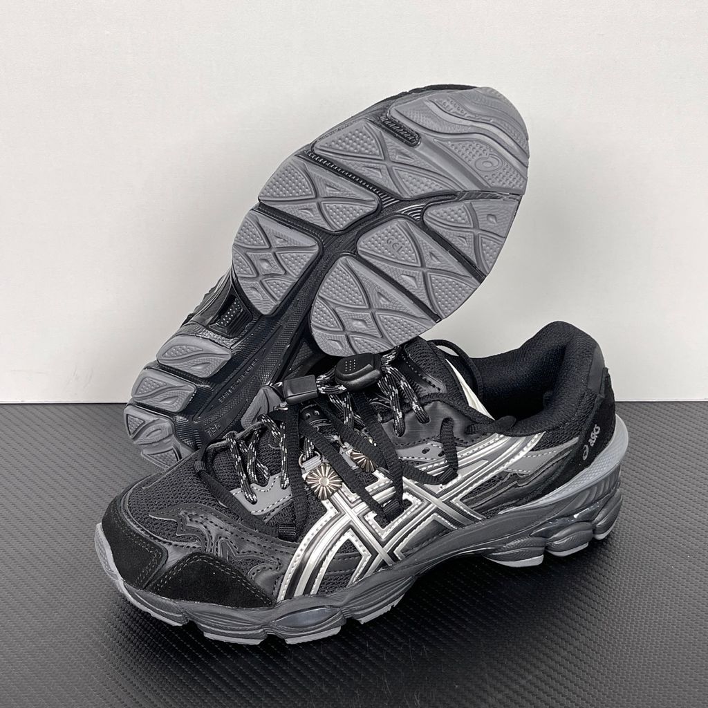 Side profile of the collaborative ASICS x TOGA Gel-Cumulus 16 sneaker in a Grey, Black, and Pure Silver colorway, featuring a breathable mesh upper, striking metallic silver overlays, sleek black accents, and a sculpted GEL-cushioned midsole.