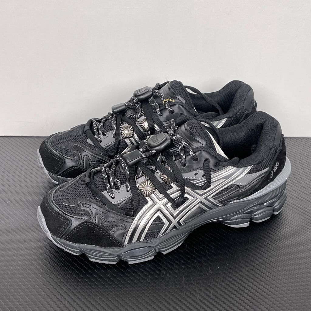 Side profile of the collaborative ASICS x TOGA Gel-Cumulus 16 sneaker in a Grey, Black, and Pure Silver colorway, featuring a breathable mesh upper, striking metallic silver overlays, sleek black accents, and a sculpted GEL-cushioned midsole.
