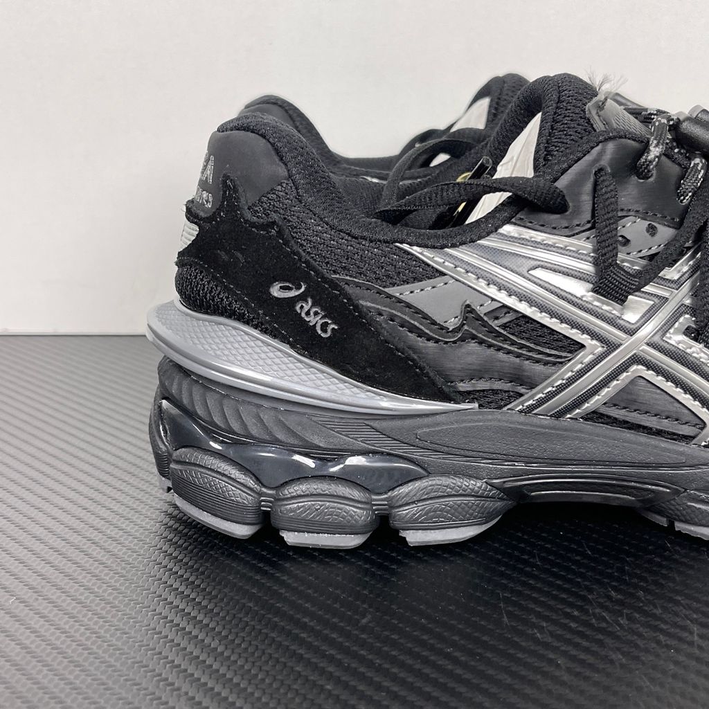 Side profile of the collaborative ASICS x TOGA Gel-Cumulus 16 sneaker in a Grey, Black, and Pure Silver colorway, featuring a breathable mesh upper, striking metallic silver overlays, sleek black accents, and a sculpted GEL-cushioned midsole.