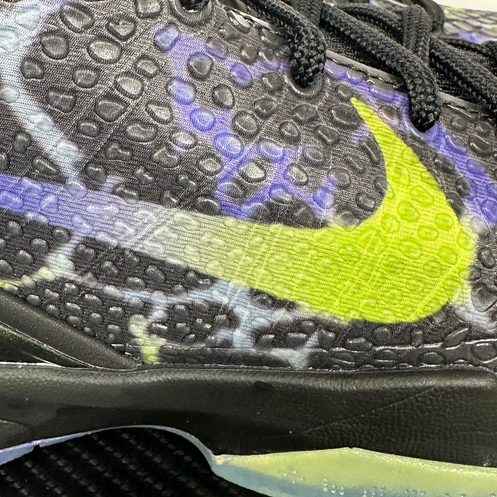 Side profile of the Nike Kobe 6 Protro "Coals" basketball shoe, featuring a stealthy black textured reptilian scale upper, vibrant Venom Green Swoosh and laces, contrasting Purple Venom accents, and a responsive Zoom Air midsole.