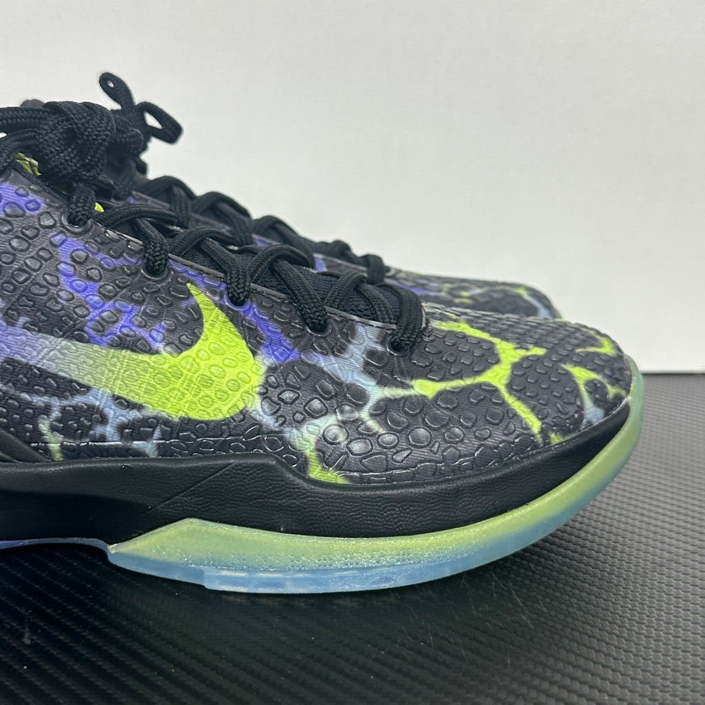 Side profile of the Nike Kobe 6 Protro "Coals" basketball shoe, featuring a stealthy black textured reptilian scale upper, vibrant Venom Green Swoosh and laces, contrasting Purple Venom accents, and a responsive Zoom Air midsole.