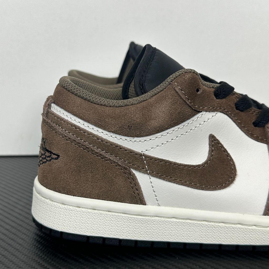 Side profile of the Air Jordan 1 Low sneaker featuring a crisp white leather base, rich earthy brown Palomino overlays, a striking Wild Berry purple Swoosh, and a classic white midsole.